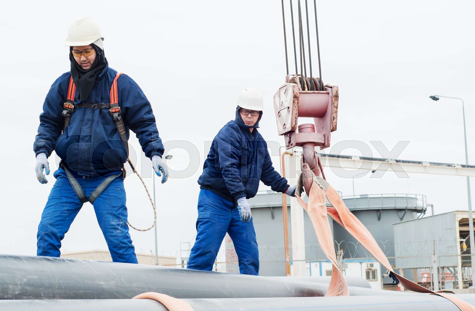 Work on unloading of pipes for construction. | Stock image | Colourbox