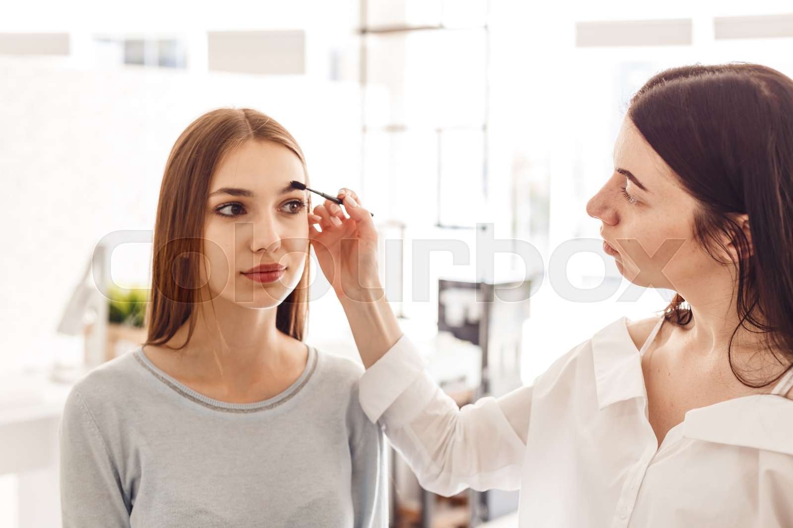 Master makeup corrects, and gives shape for eyebrows in a beauty salon