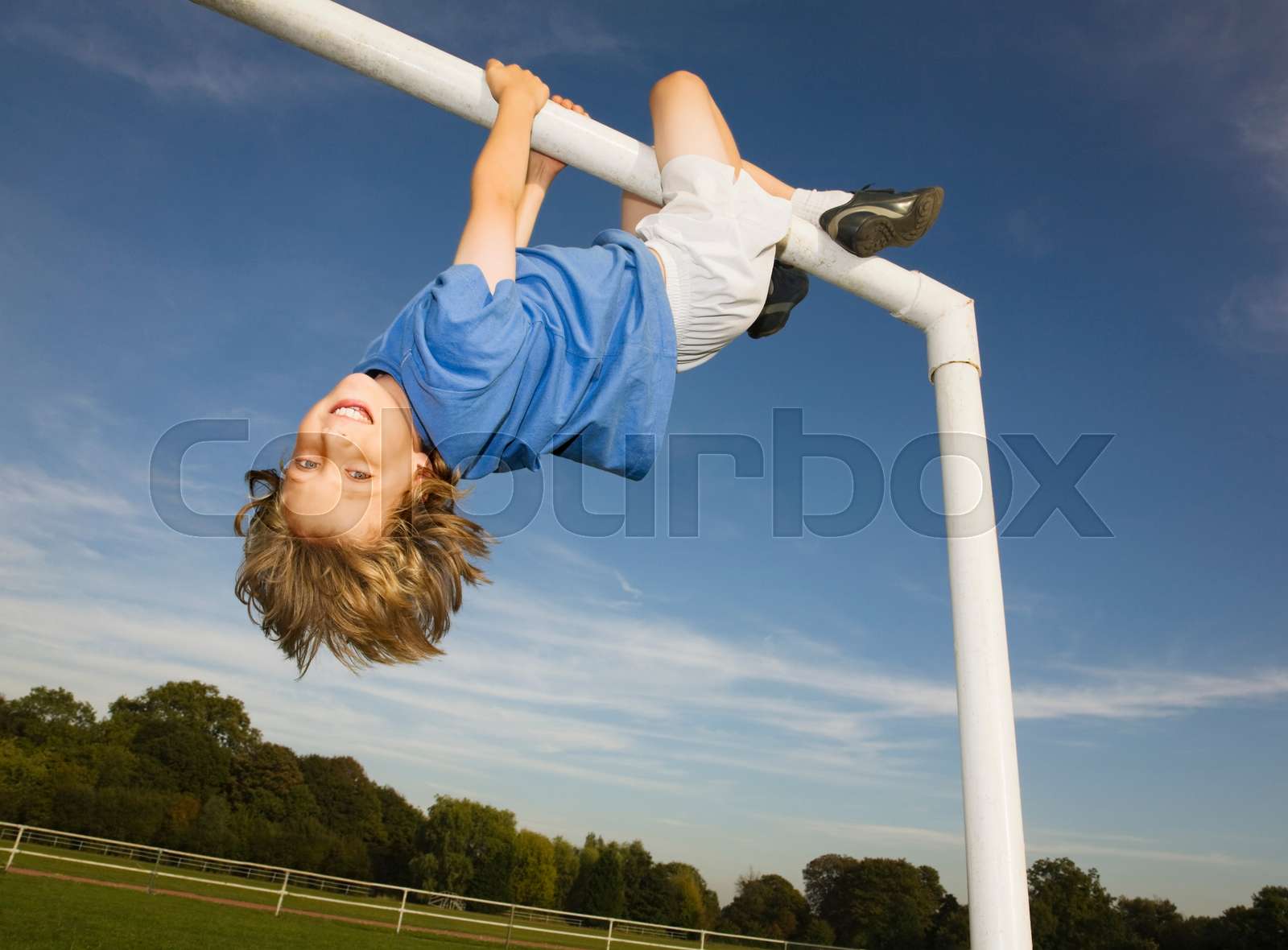 Boy hanging off goal post Stock image Colourbox