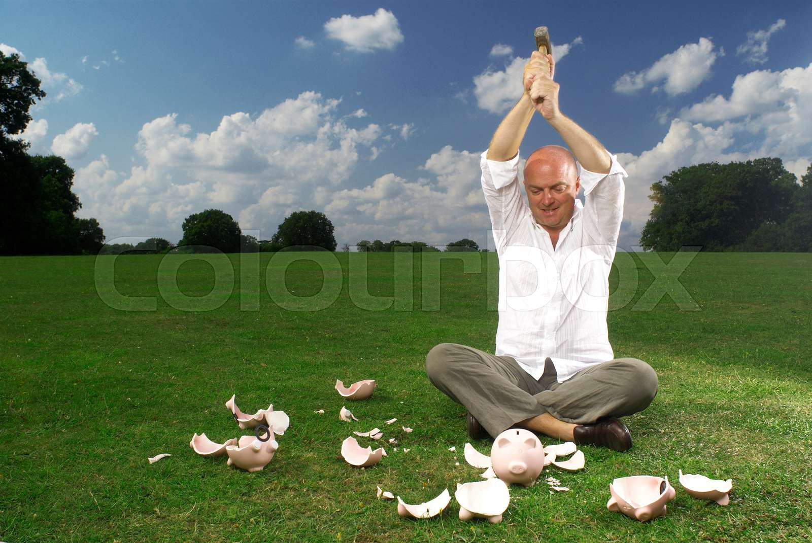 man smashing piggy banks | Stock image | Colourbox