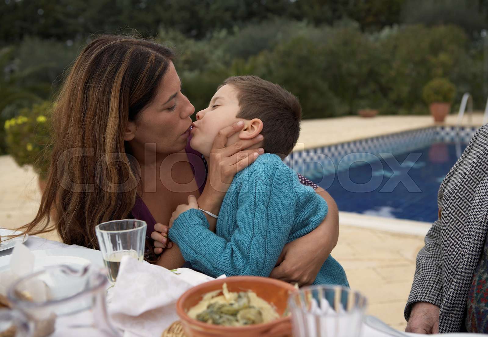 Mother kissing son at the table  Stock image  Colourbox