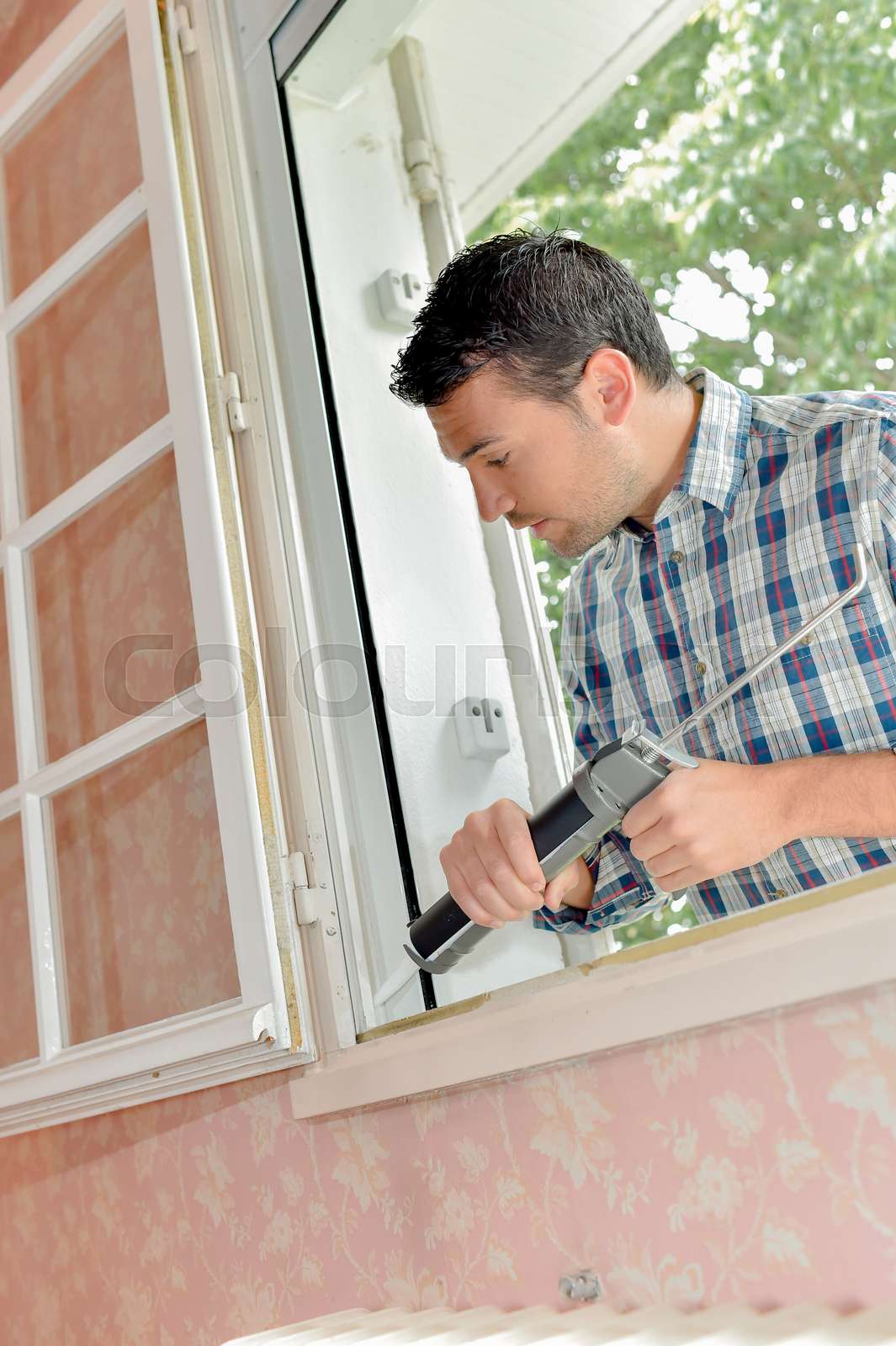 man fixing window Stock image Colourbox