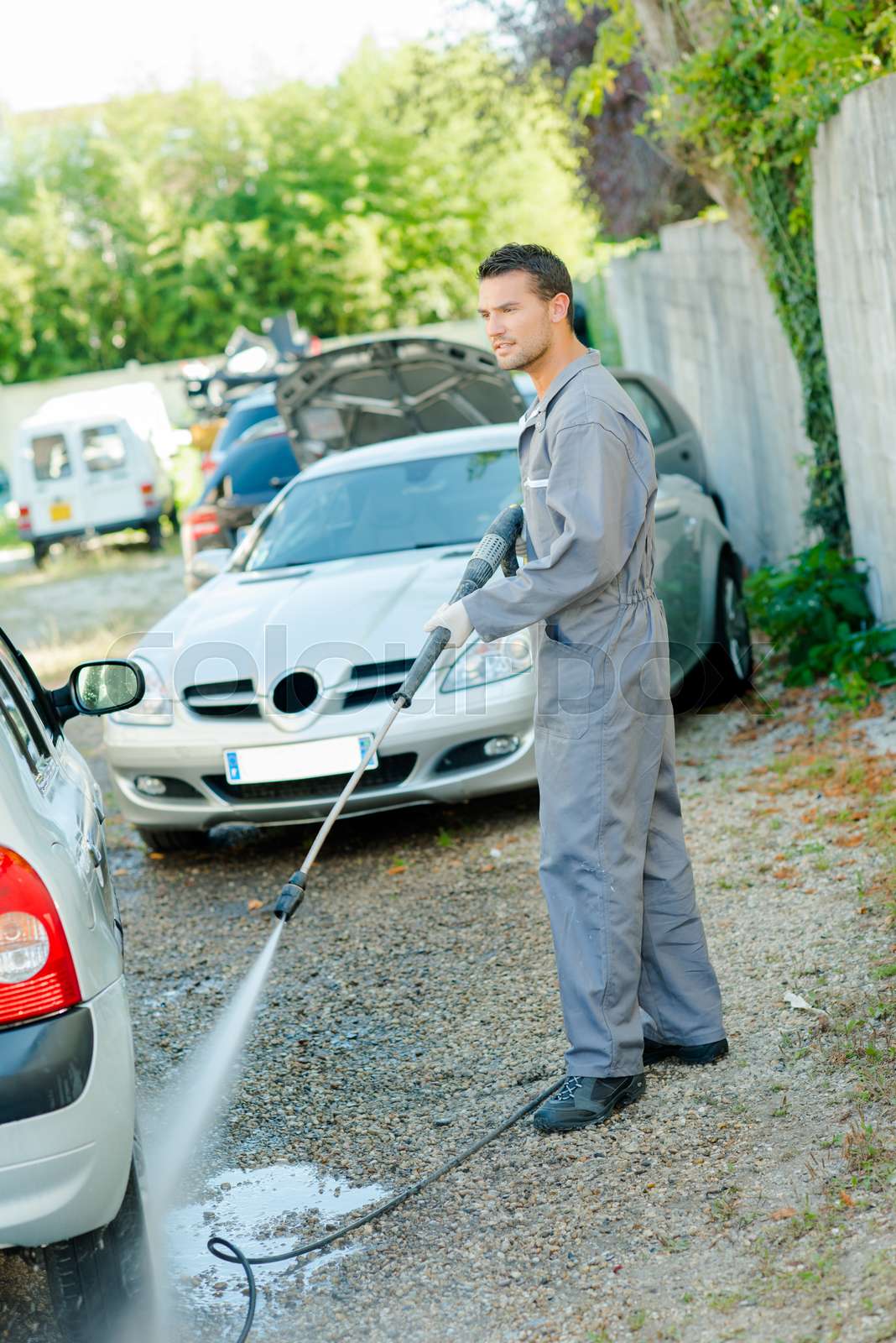 Man pressure washing a car Stock image Colourbox
