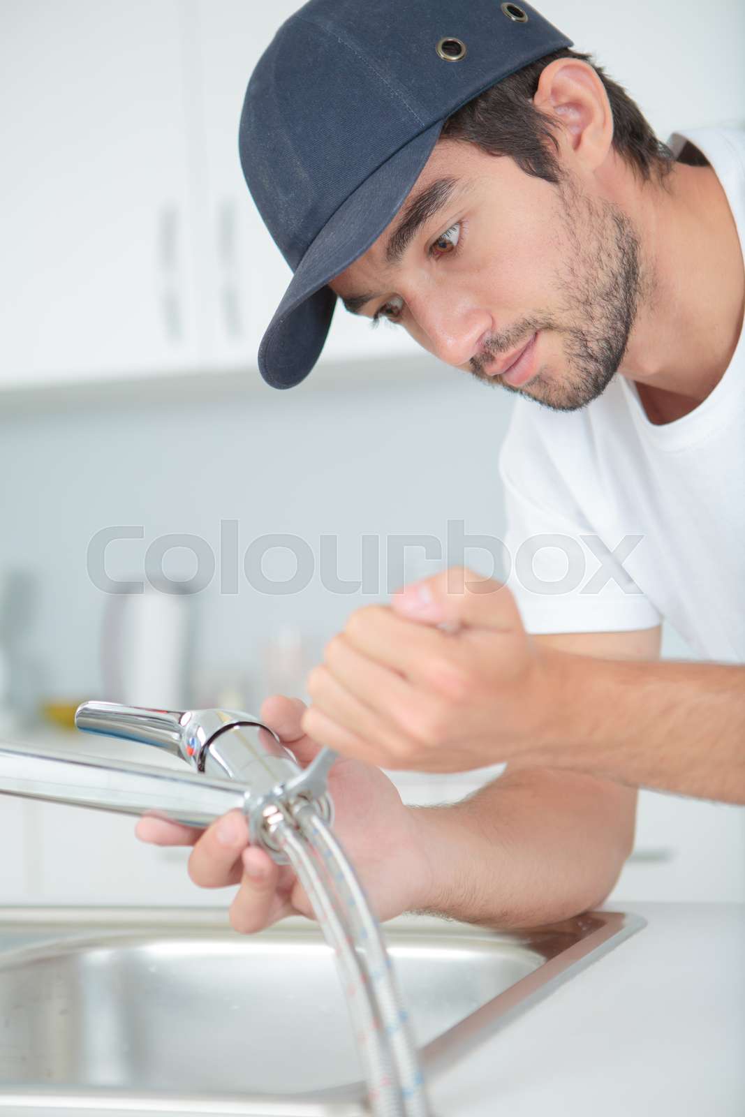 fixing a loose tap Stock image Colourbox