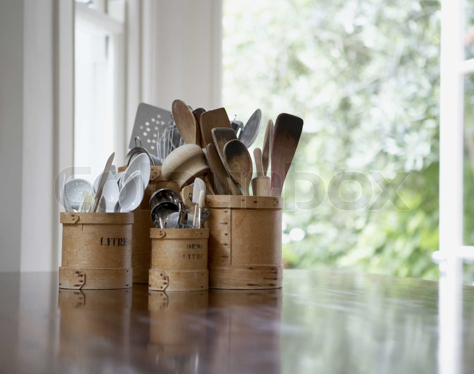 Kitchen utensils in containers on table in the kitchen | Stock image