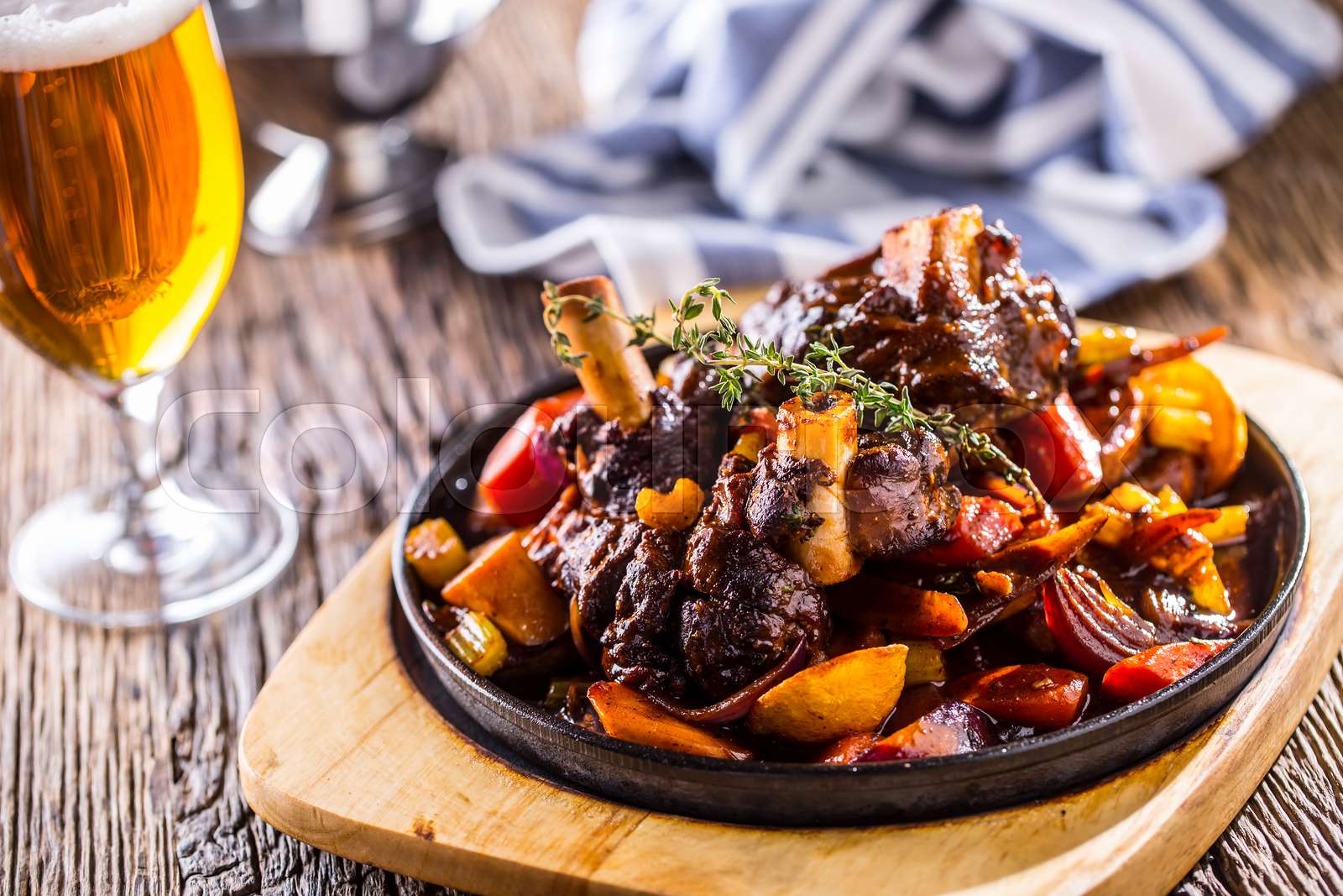 Lamb shank.Confit lamb shank with potatoes vegetable and draft beer in