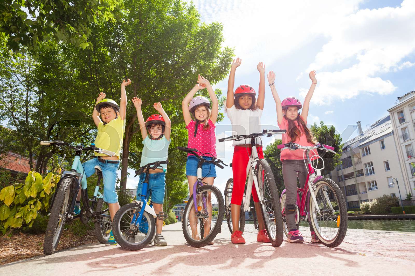 Happy bicycle riders standing in city park | Stock image | Colourbox