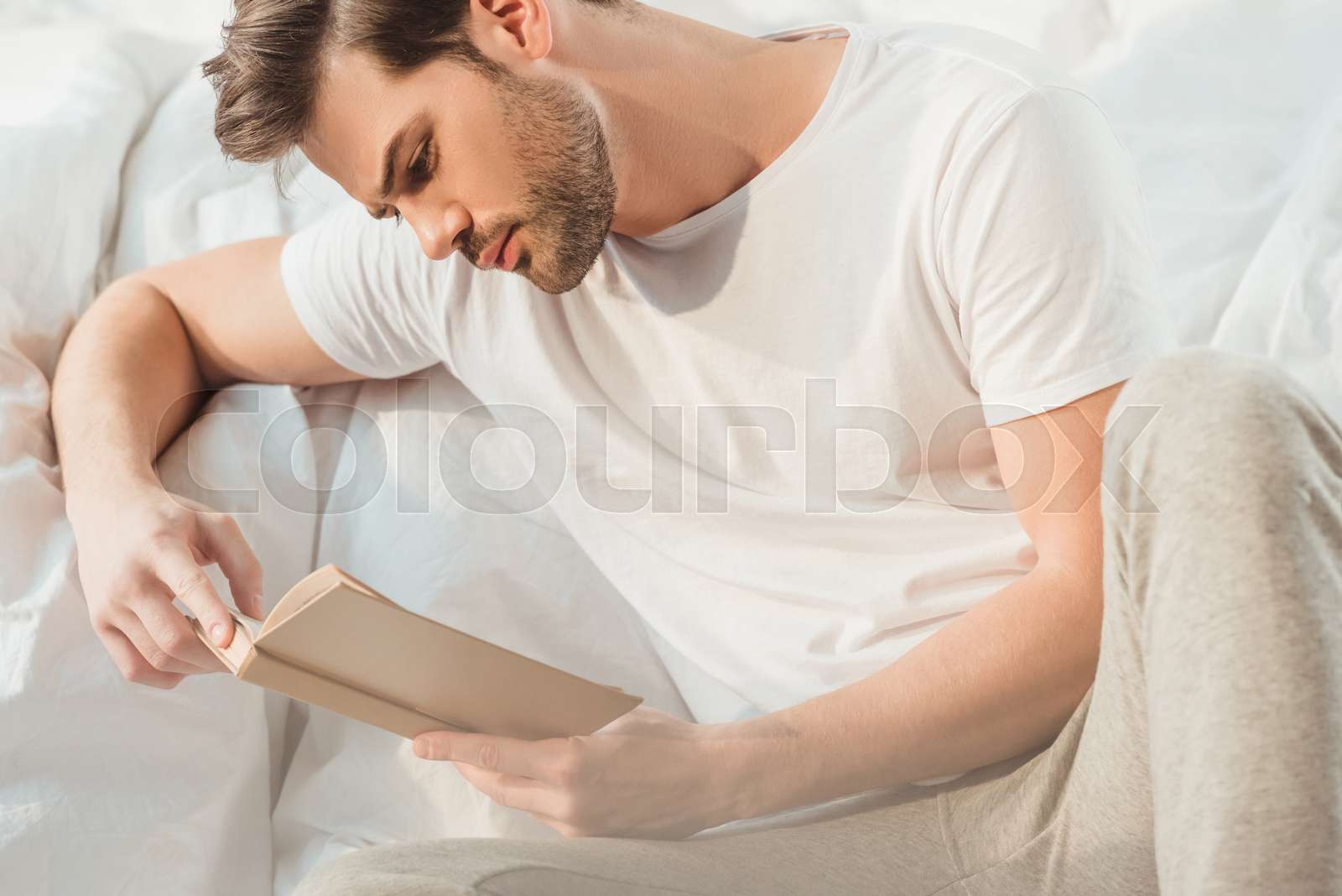 man reading book in bed | Stock image | Colourbox