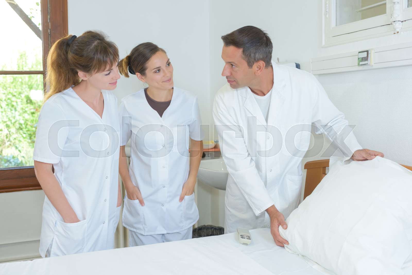 Nurses learning how to make hospital bed Stock image Colourbox