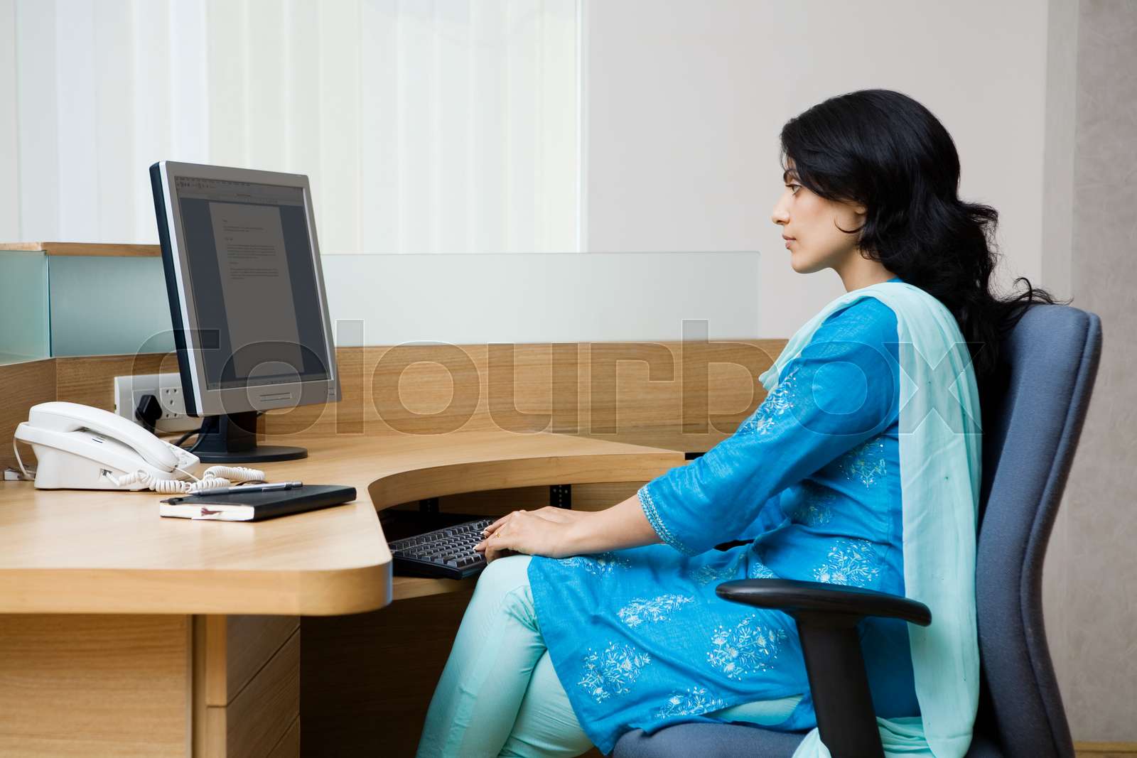 Indian woman working at her desk | Stock image | Colourbox