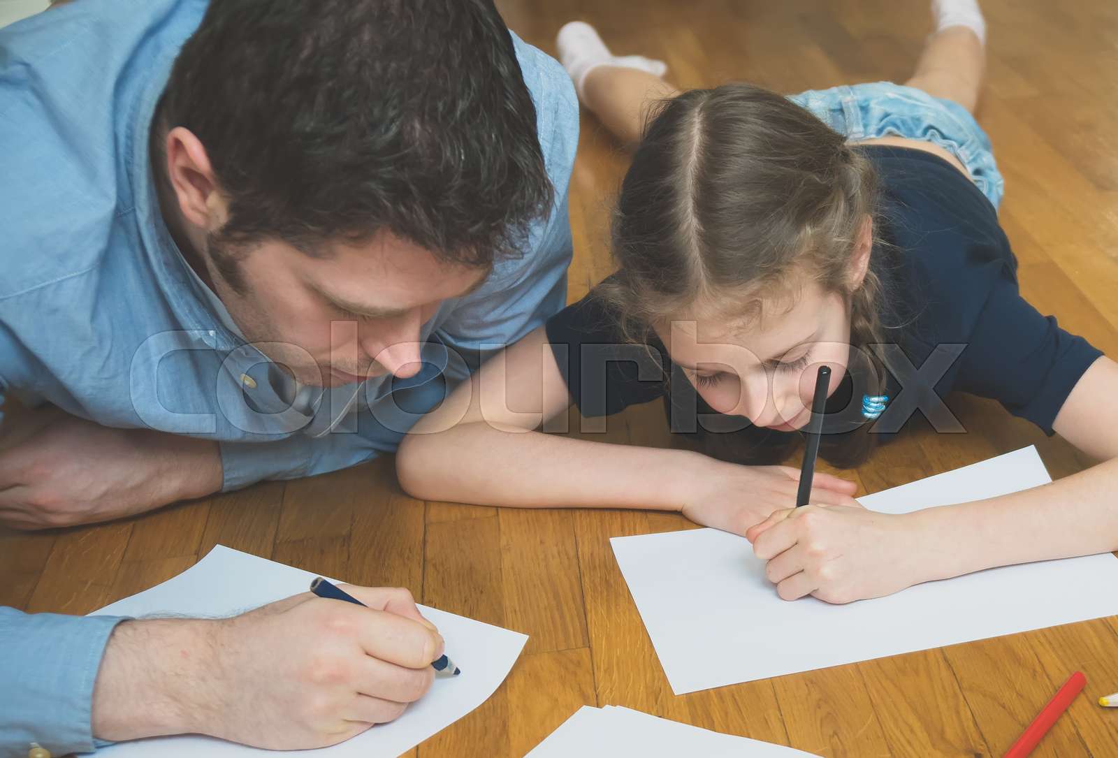 Father and her daughter drawing on the floor. | Stock image | Colourbox