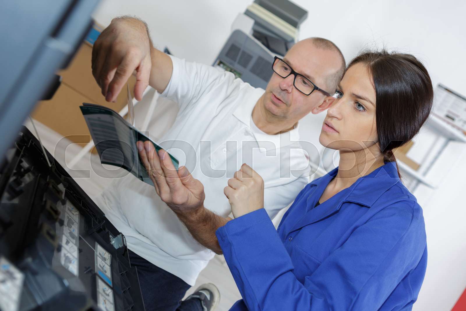 worker instructing female apprentice in workshop | Stock image | Colourbox
