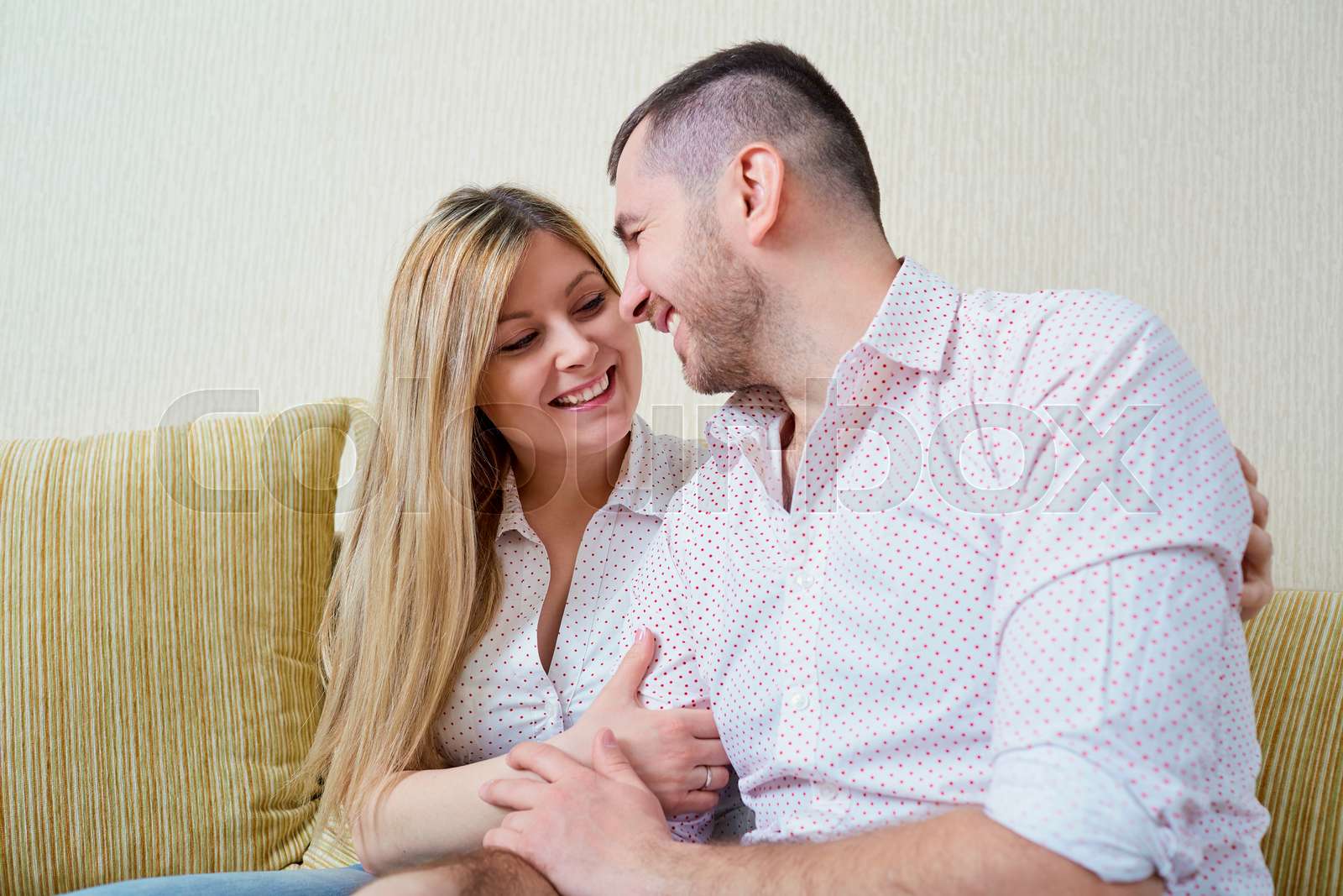 Happy husband and wife sitting in the room. Stock image Colourbox