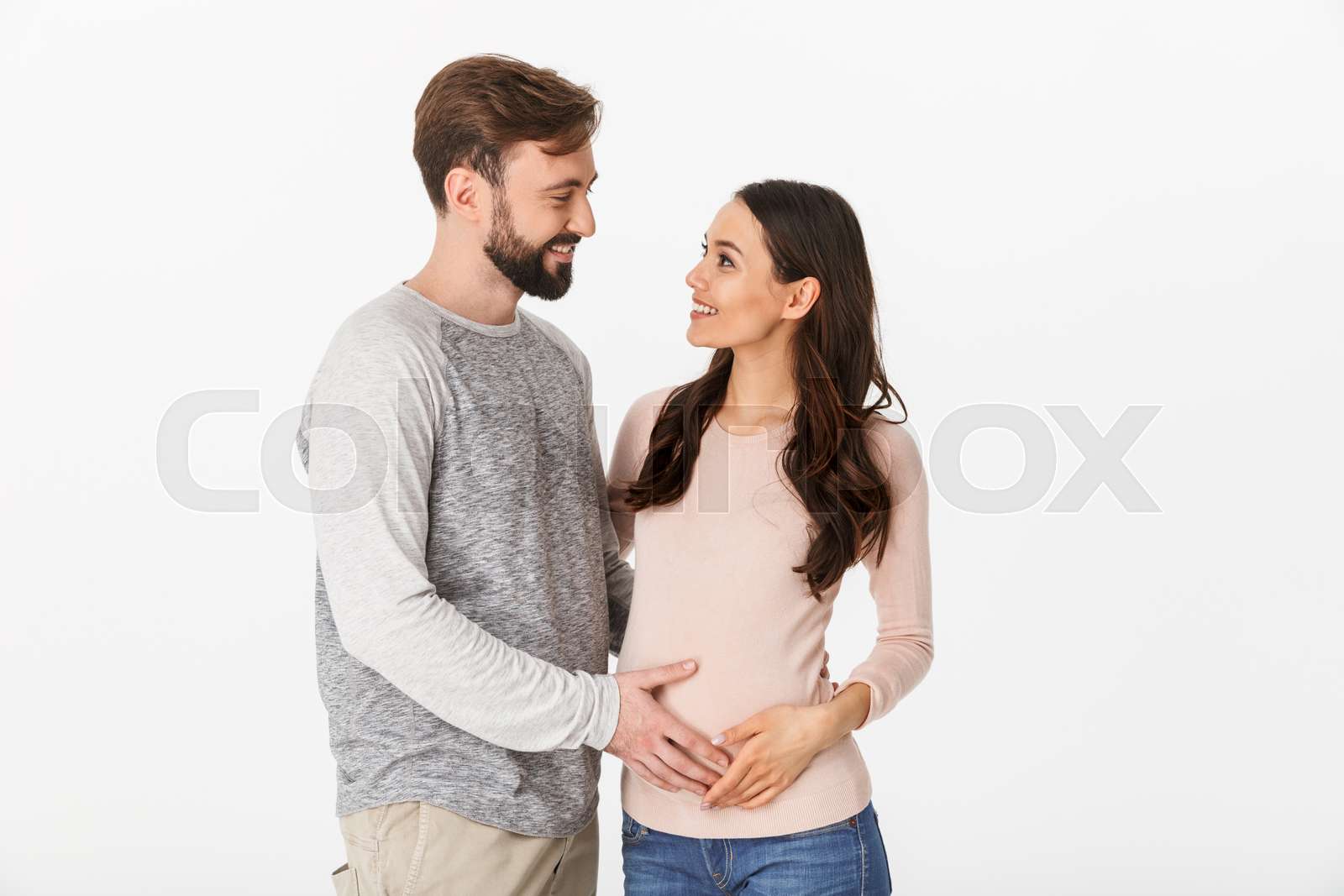 Cheerful young man standing with his pregnant woman | Stock image