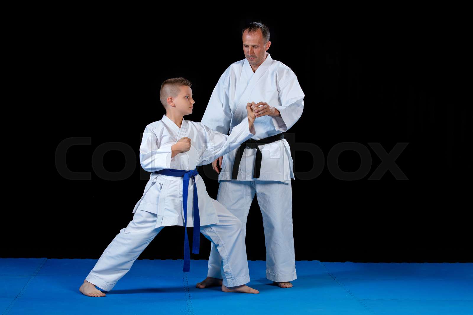 Male karate instructor training little children in dojo | Stock image