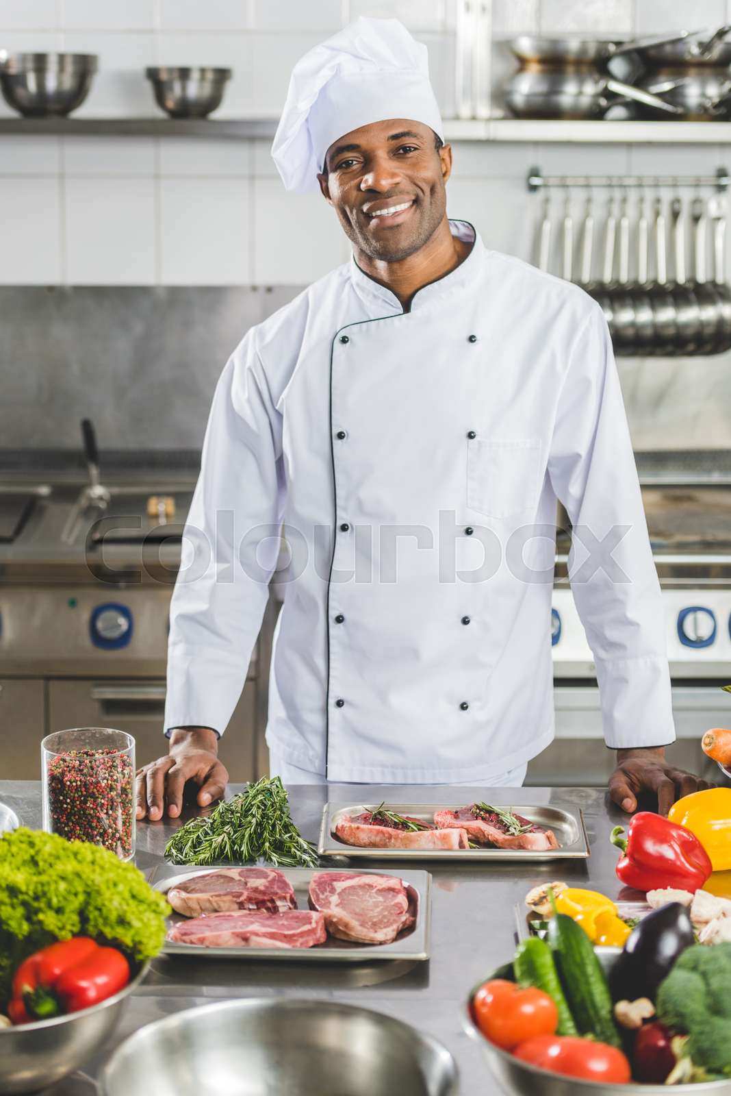 handsome african american chef looking at camera at restaurant kitchen