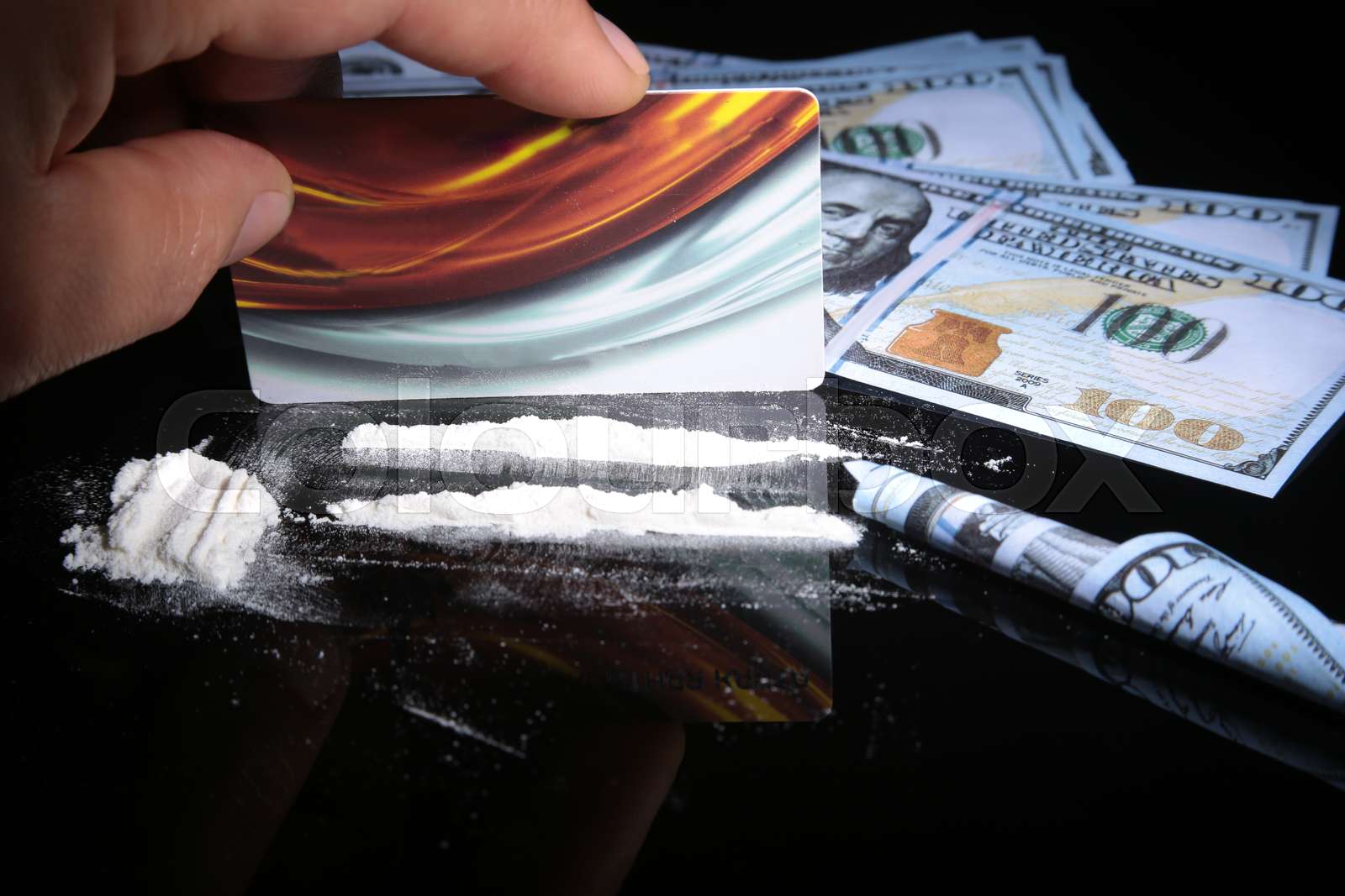 Cocaine drugs heap still life on a mirror with rolled 100 dollar