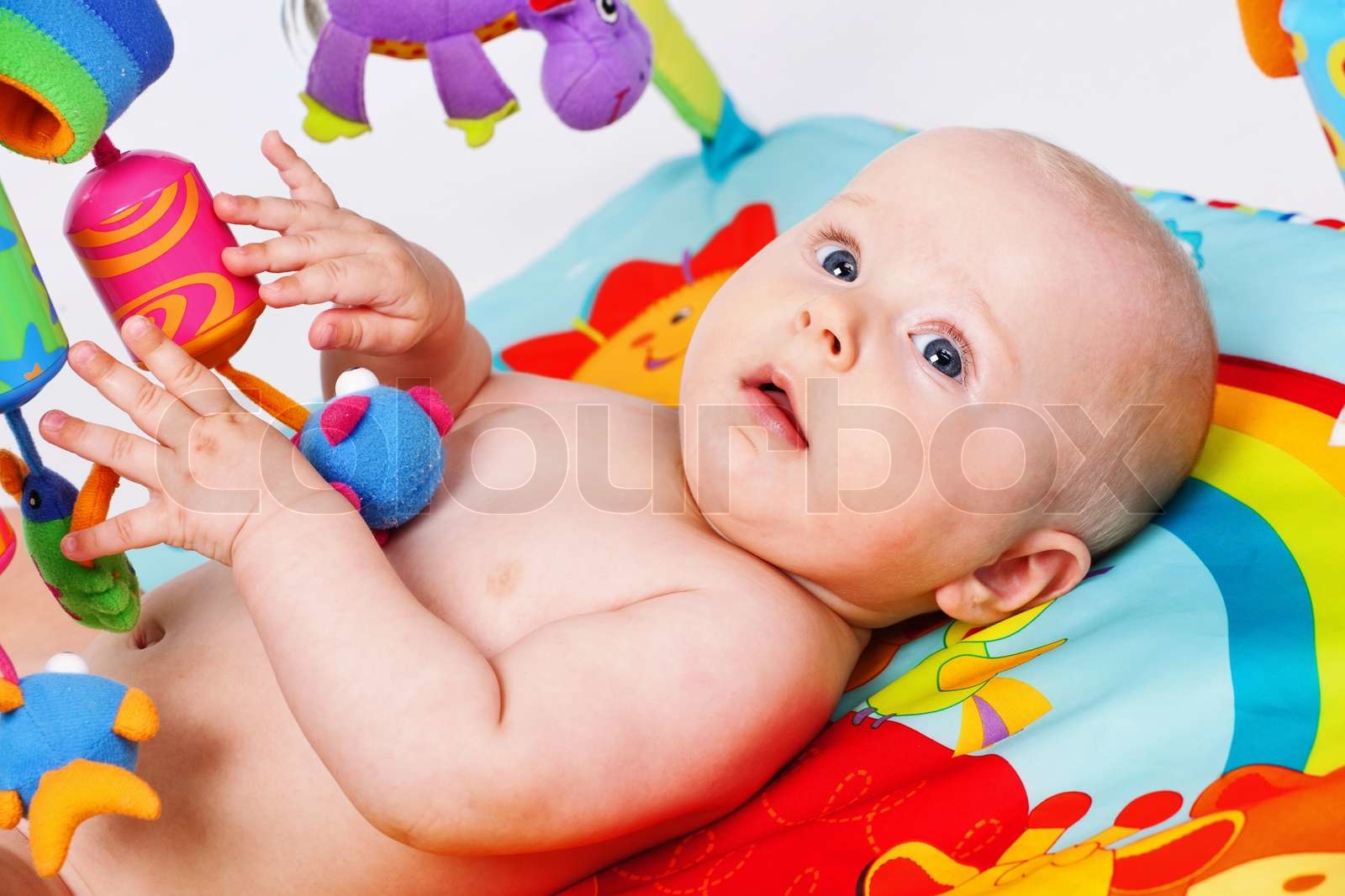 infant with toys in the bed Stock image Colourbox