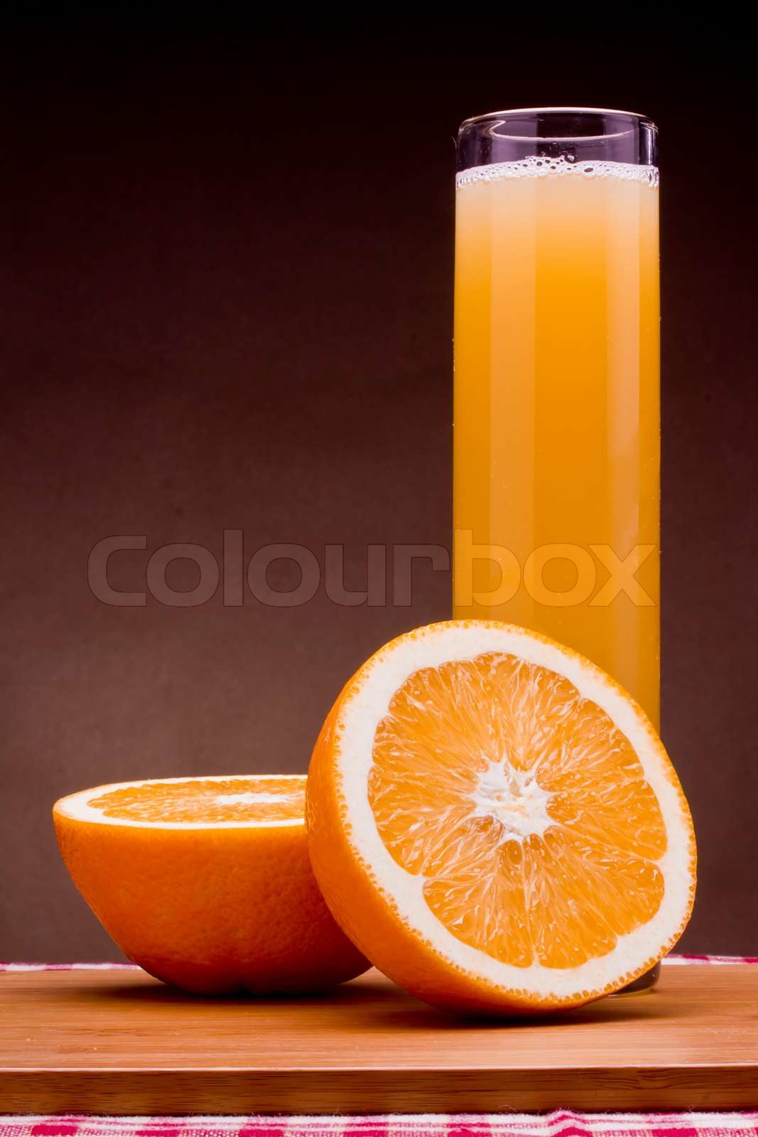 Orange juice in a tall glass and half an orange | Stock image | Colourbox