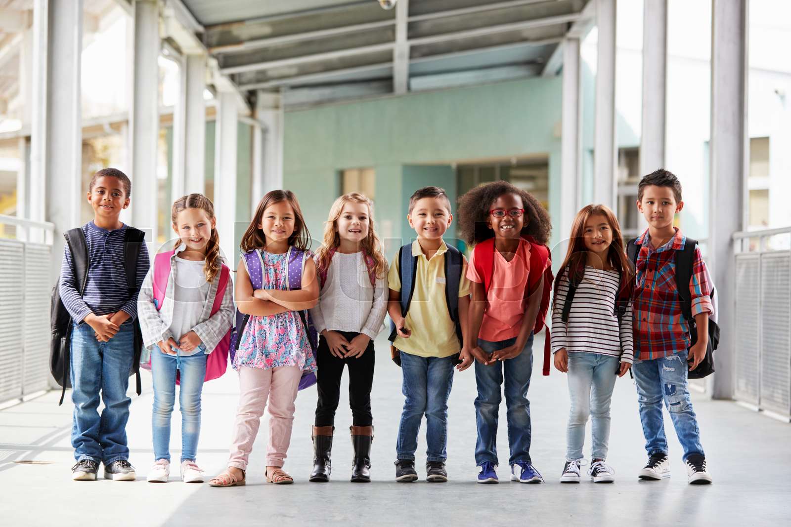 Elementary school kids stand in corridor looking at camera | Stock ...