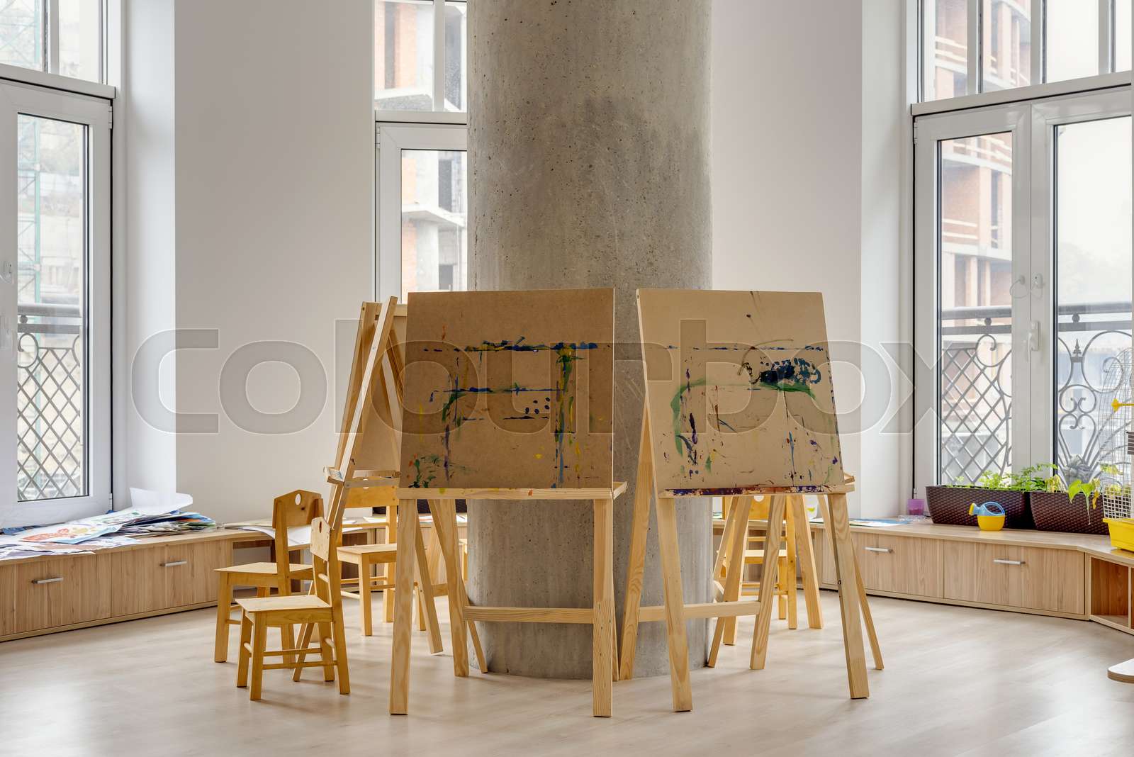 easels and wooden chairs in classroom at modern kindergarten Stock