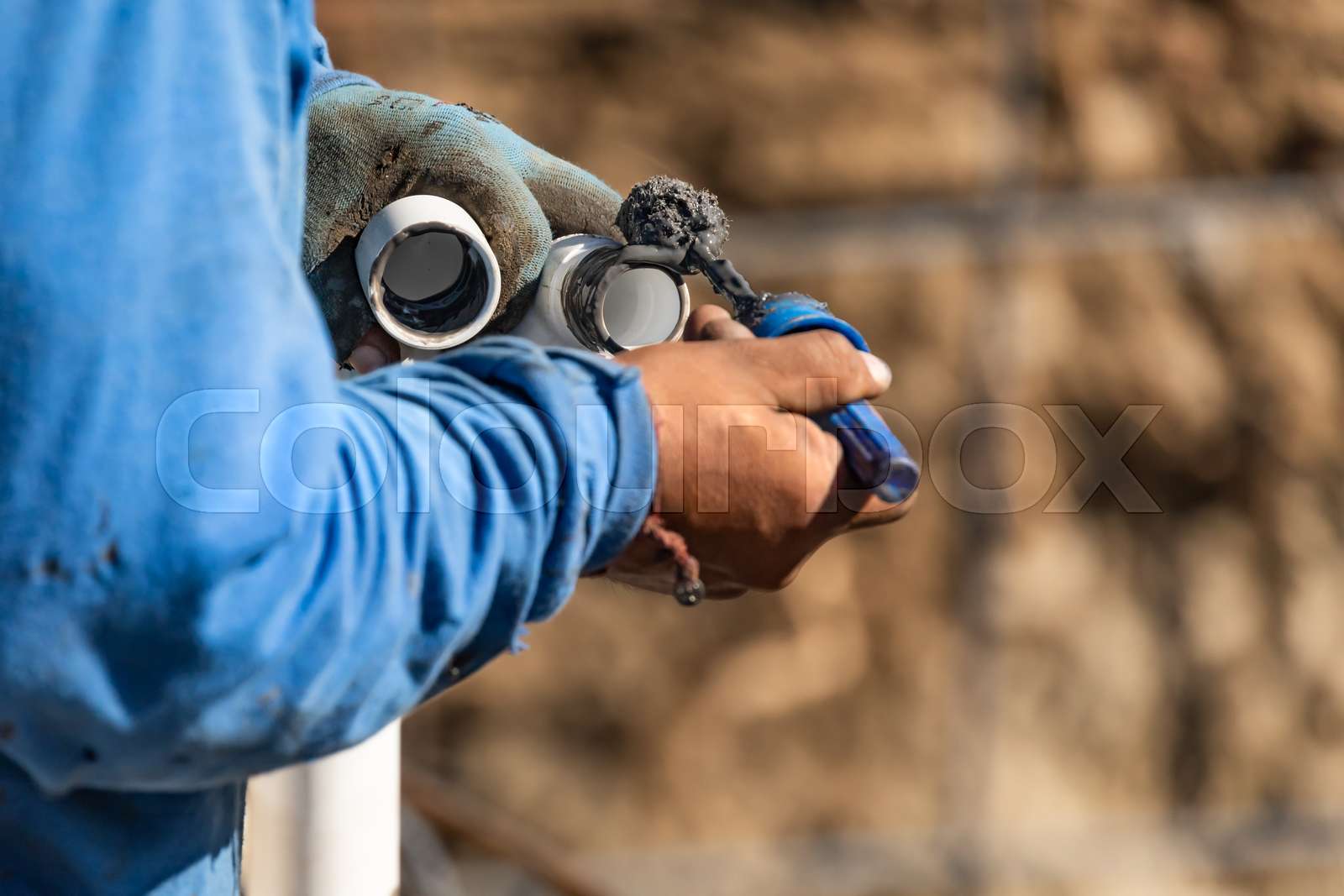 Plumber Applying Pipe Cleaner, Primer and Glue to PVC Pipe At