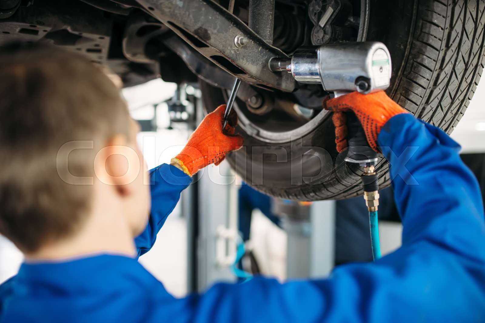 Technician with a wrench repair car suspension Stock image Colourbox
