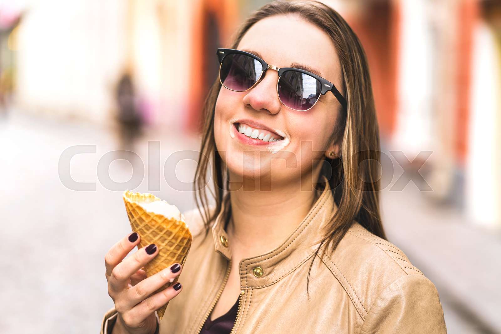 Ice cream on messy face. Happy laughing woman eating melting and