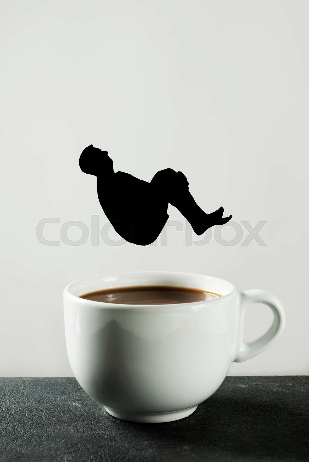 man throwing himself into a cup of coffee Stock image Colourbox