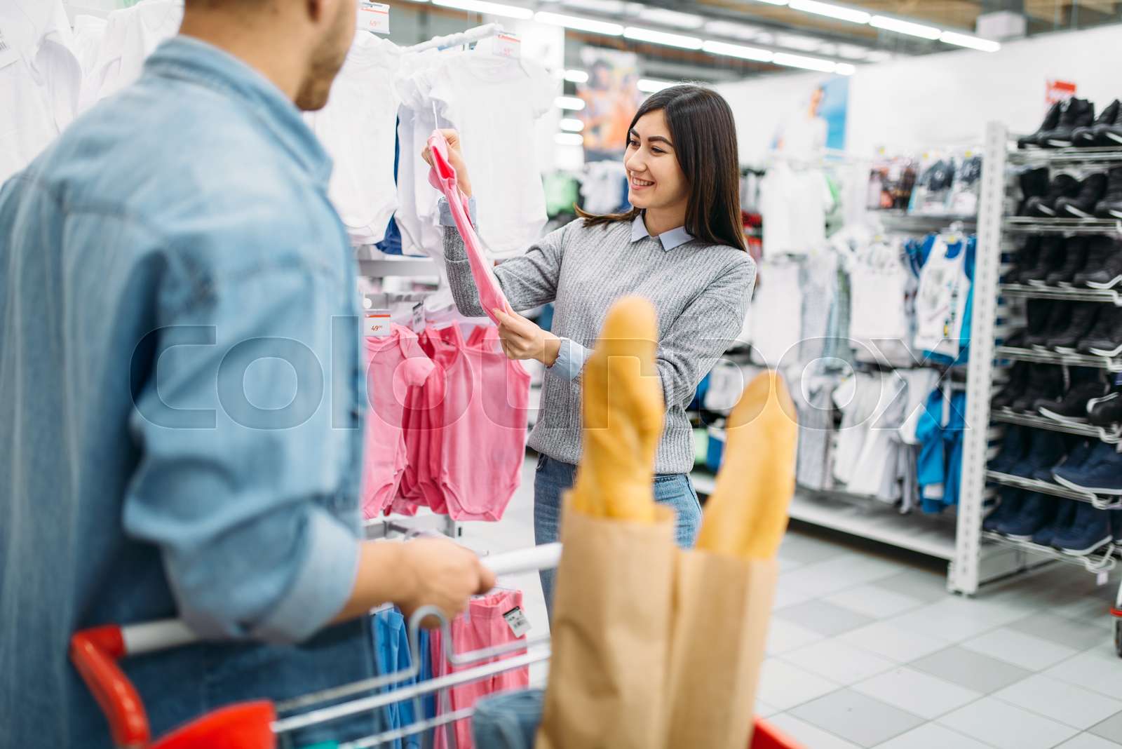 Young mother buying childrens clothes in store Stock image Colourbox