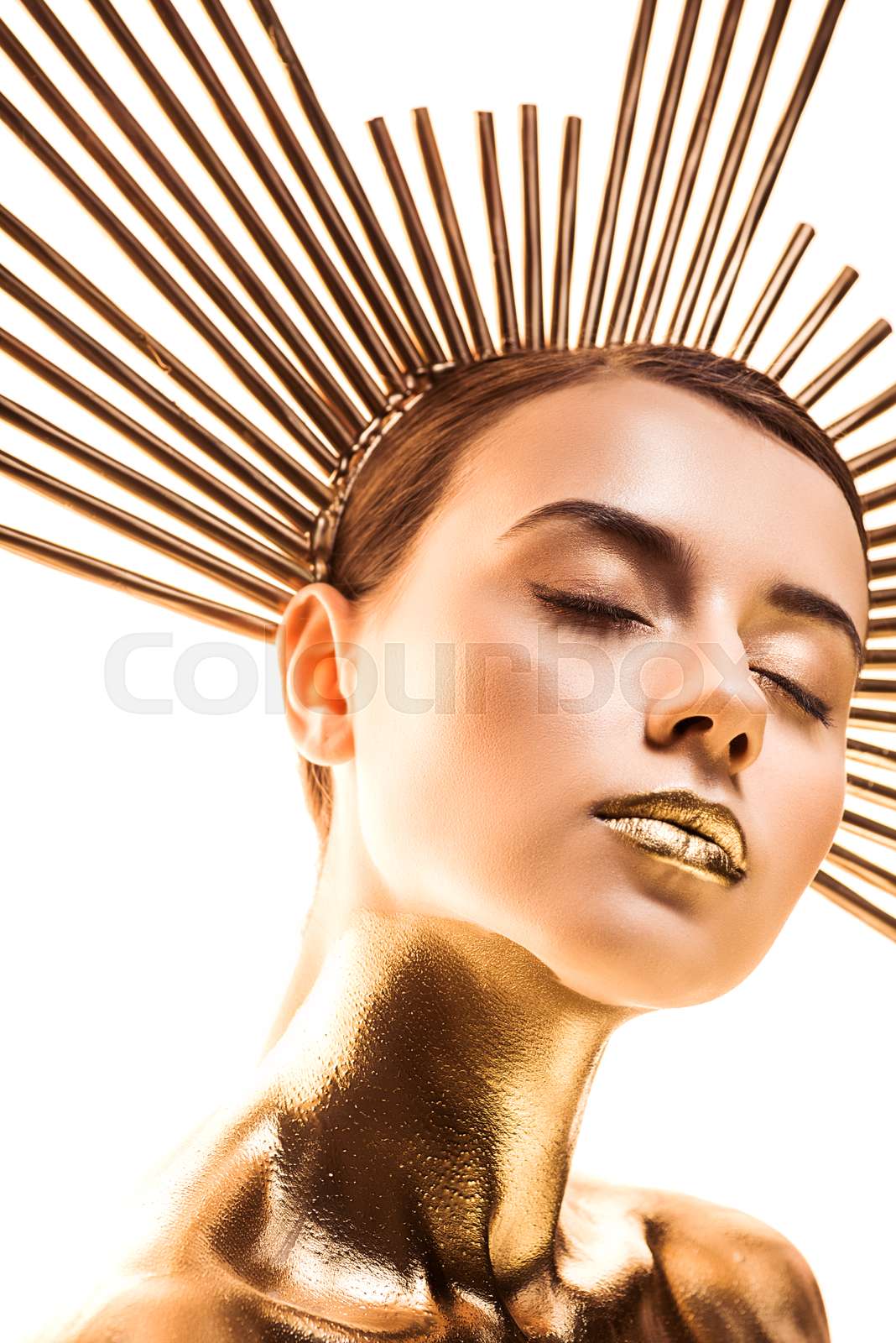 nude beautiful young woman painted in golden with accessory on head and