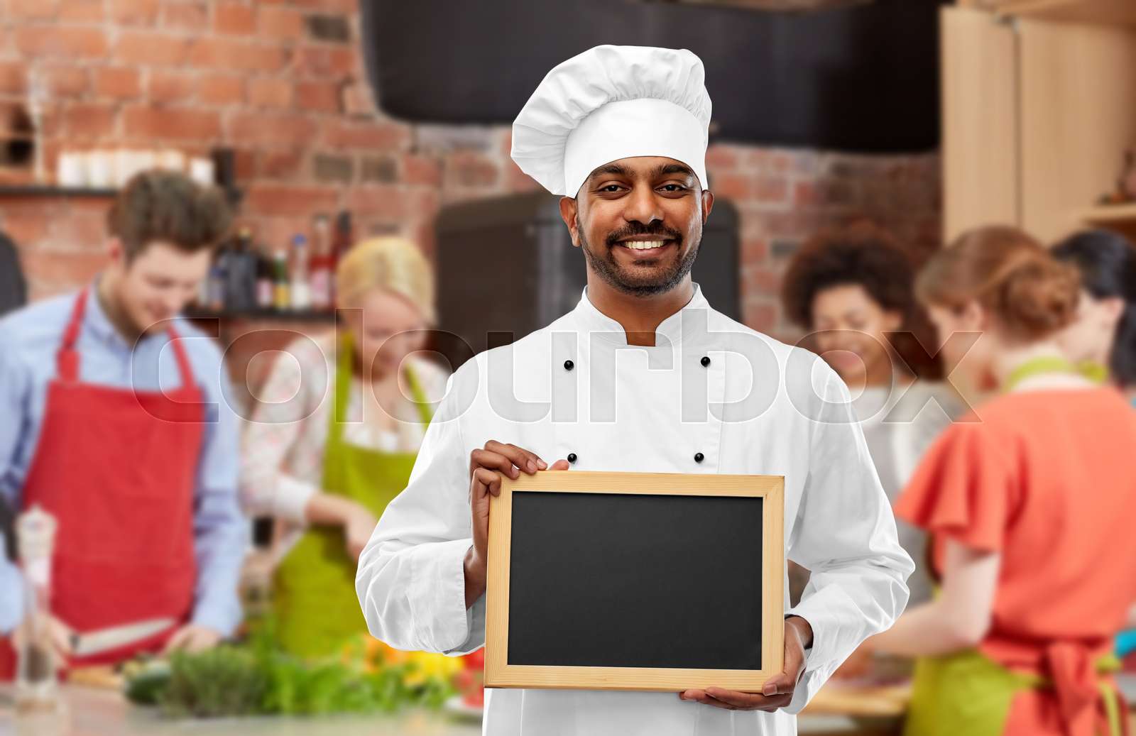 happy indian chef with chalkboard at cooking class | Stock image
