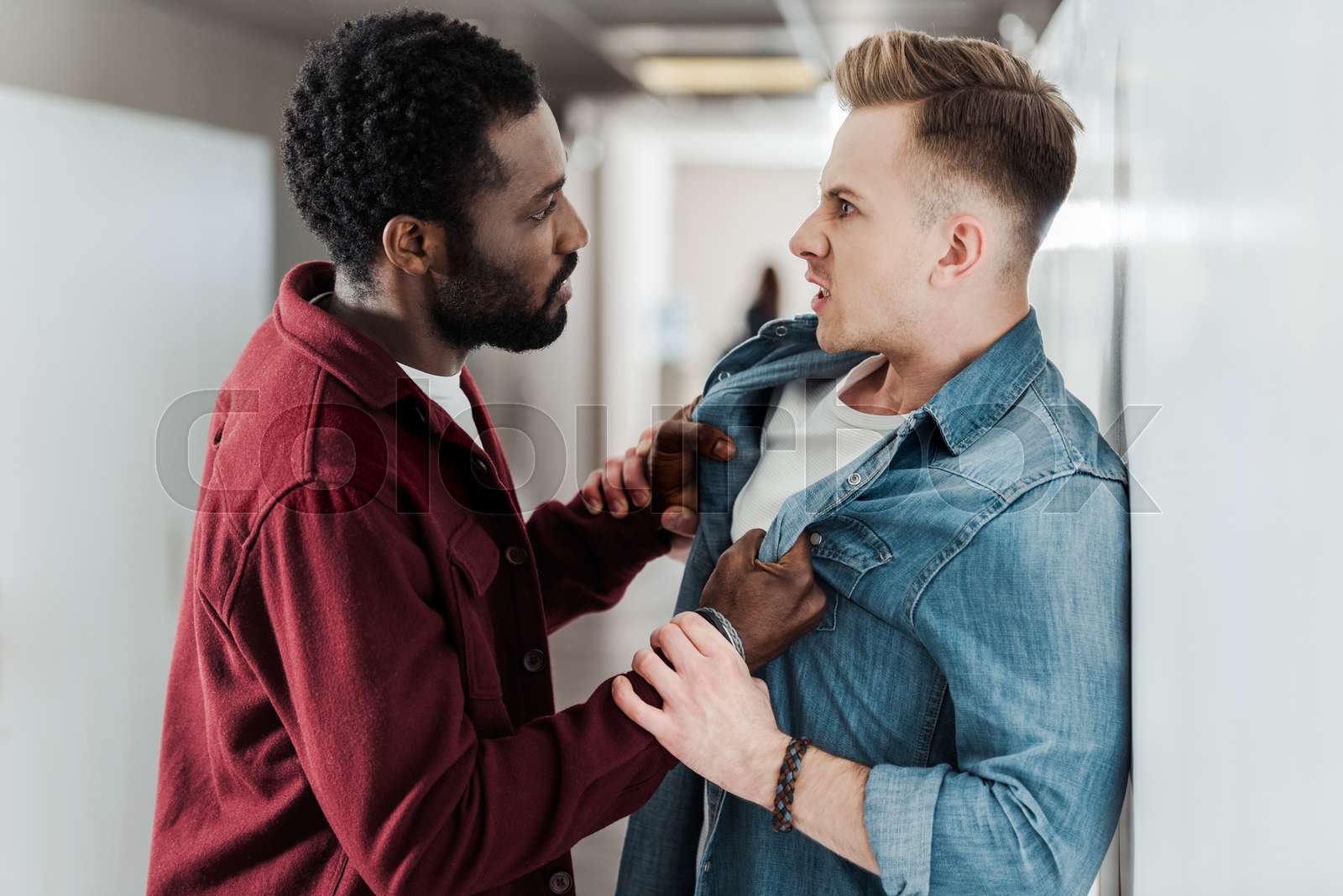 Two Multiethnic Students Fighting In Corridor In College Stock Image 