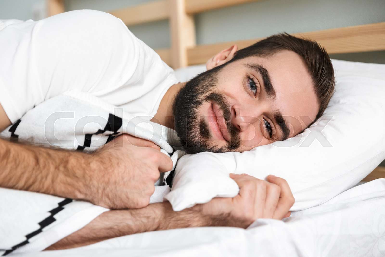Handsonme smiling man sleeping on a pillow | Stock image | Colourbox