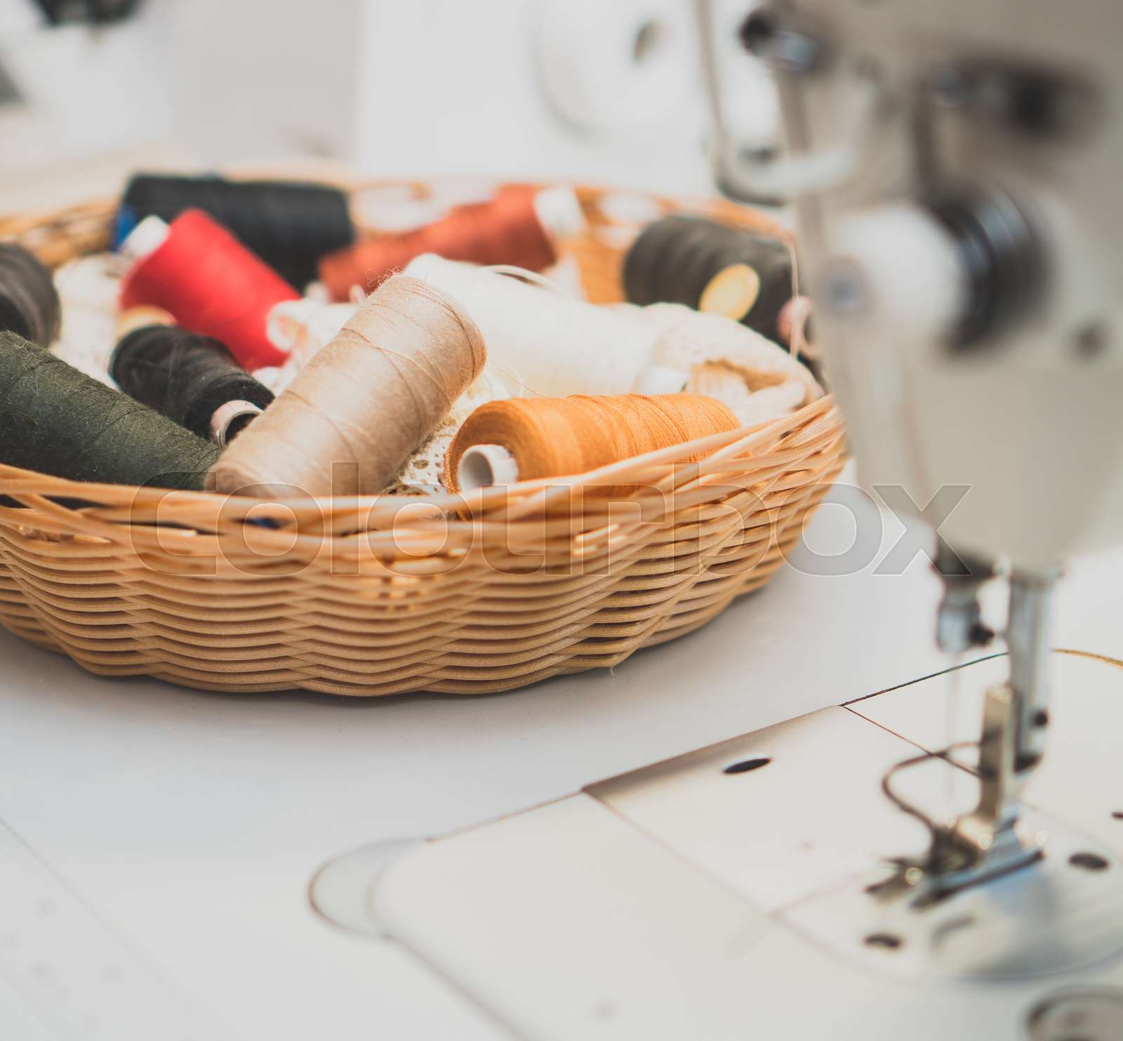 Sewing concept. Lot of thread coils next to the sewing machine. Stock