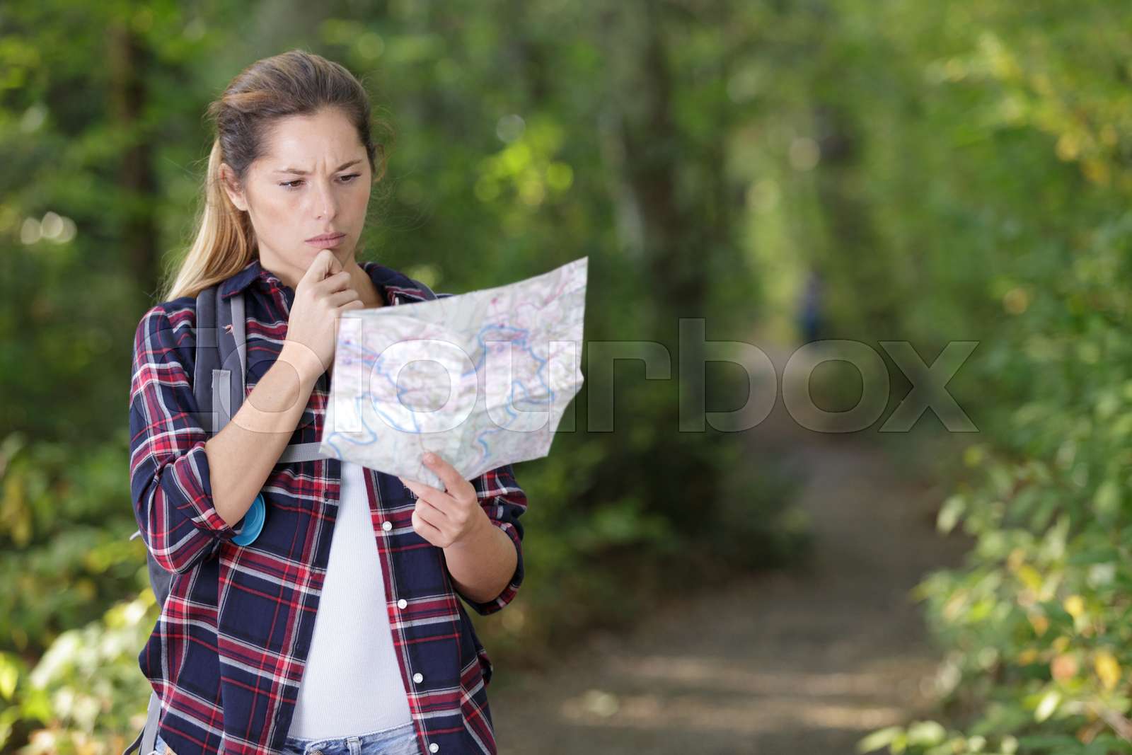 woman-on-a-woodland-path-looking-at-a-map-stock-image-colourbox