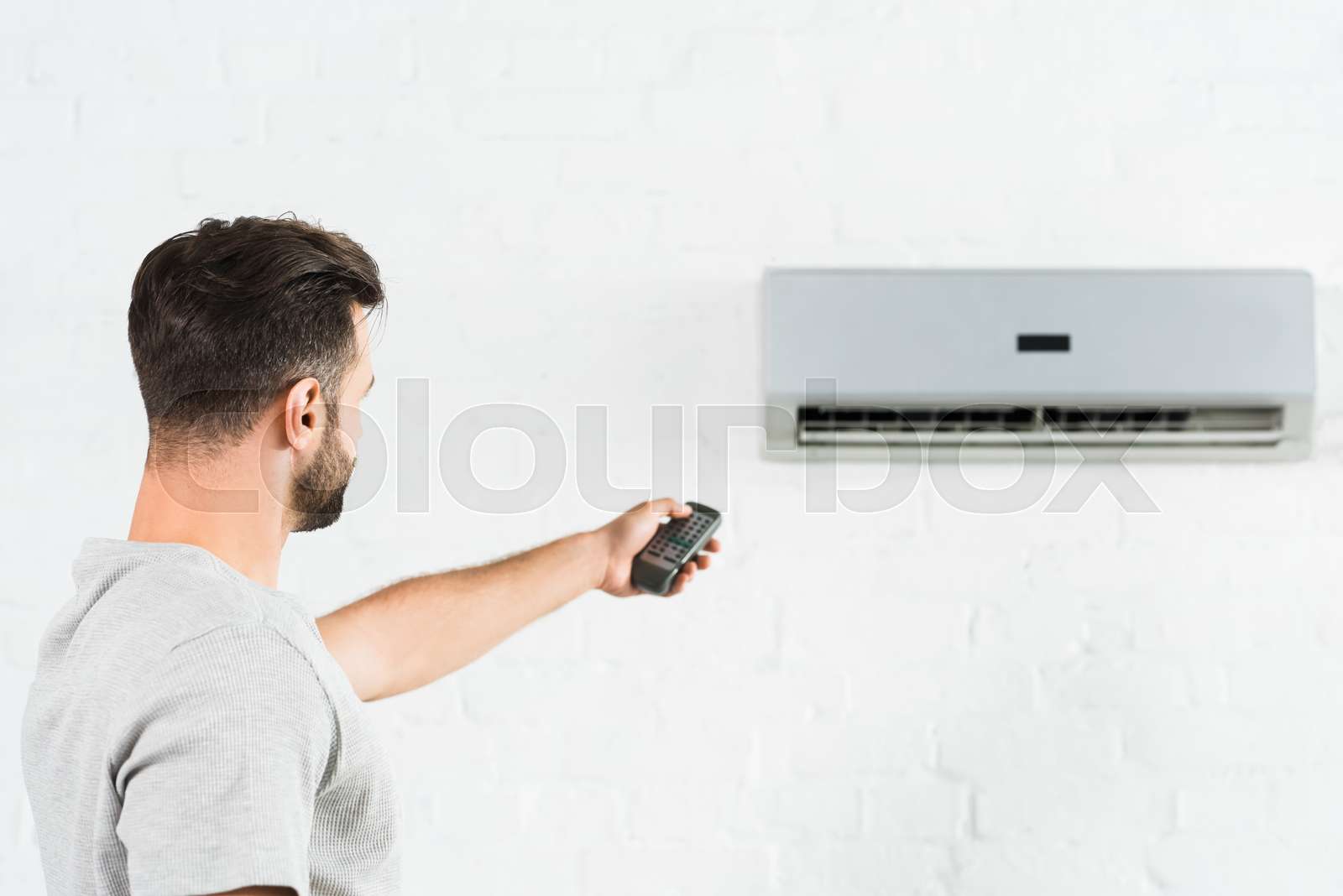 side view of man suffering from heat and switching temperature of air