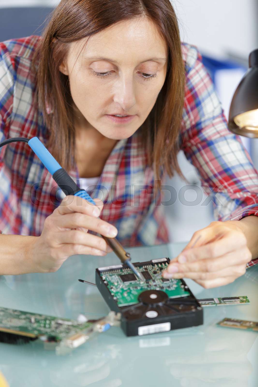 woman soldering a circuit board in her tech office Stock image