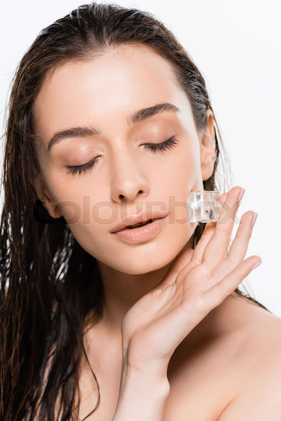 brunette wet young naked woman with closed eyes holding ice cube