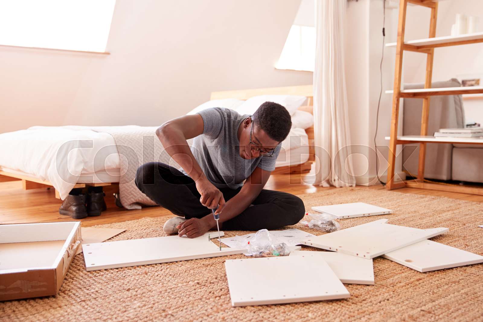 Man In New Home Putting Together Self Assembly Furniture Stock image