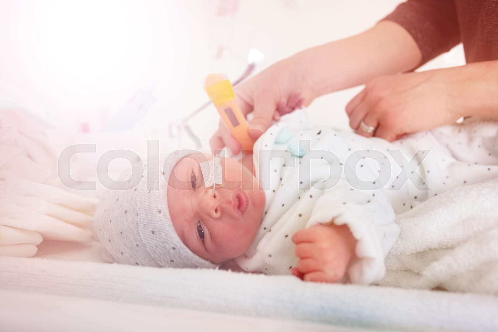 Premature born in ICU with thermometer, hospital Stock image Colourbox
