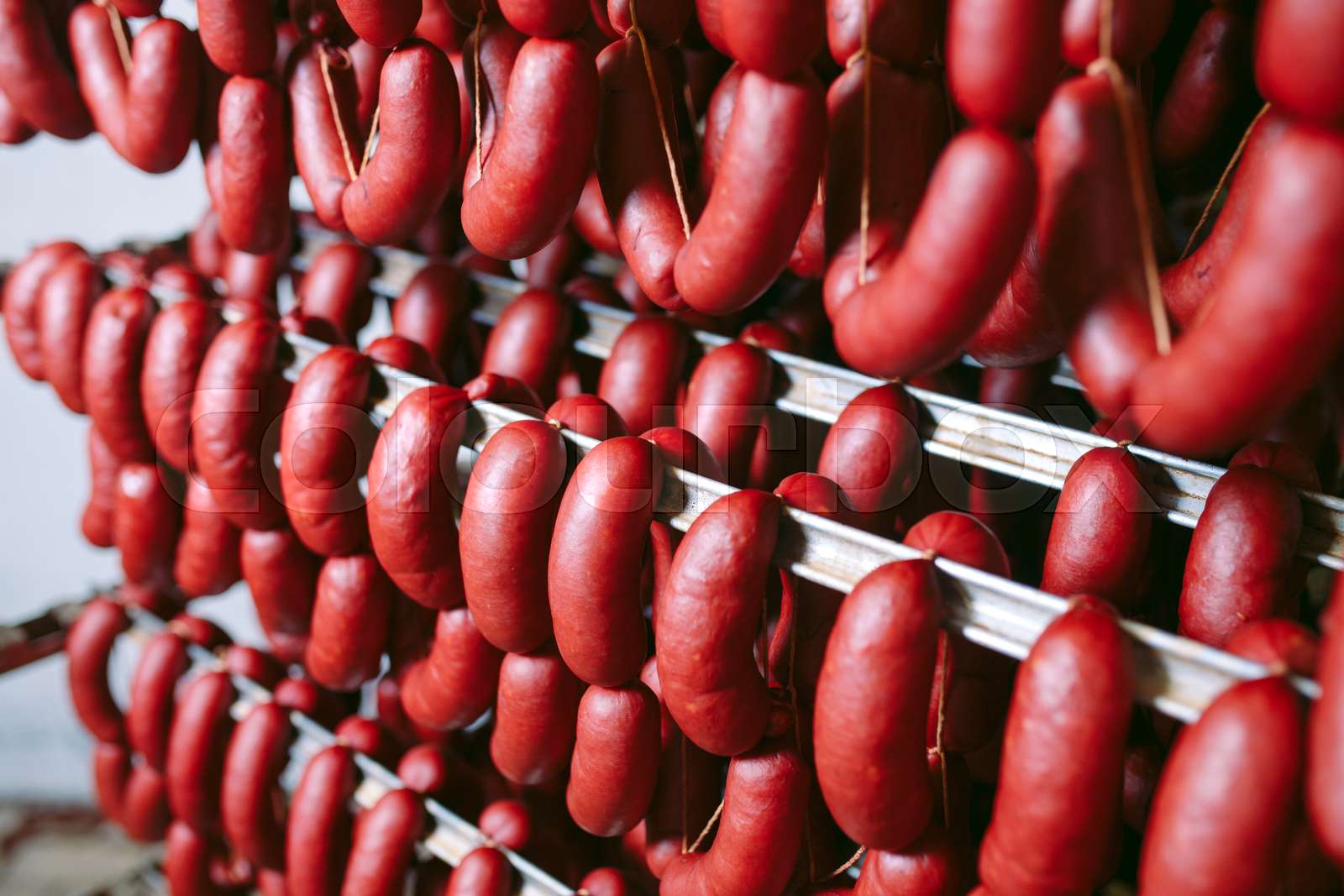 Smoked sausage in the oven. Sausage production in the factory Stock