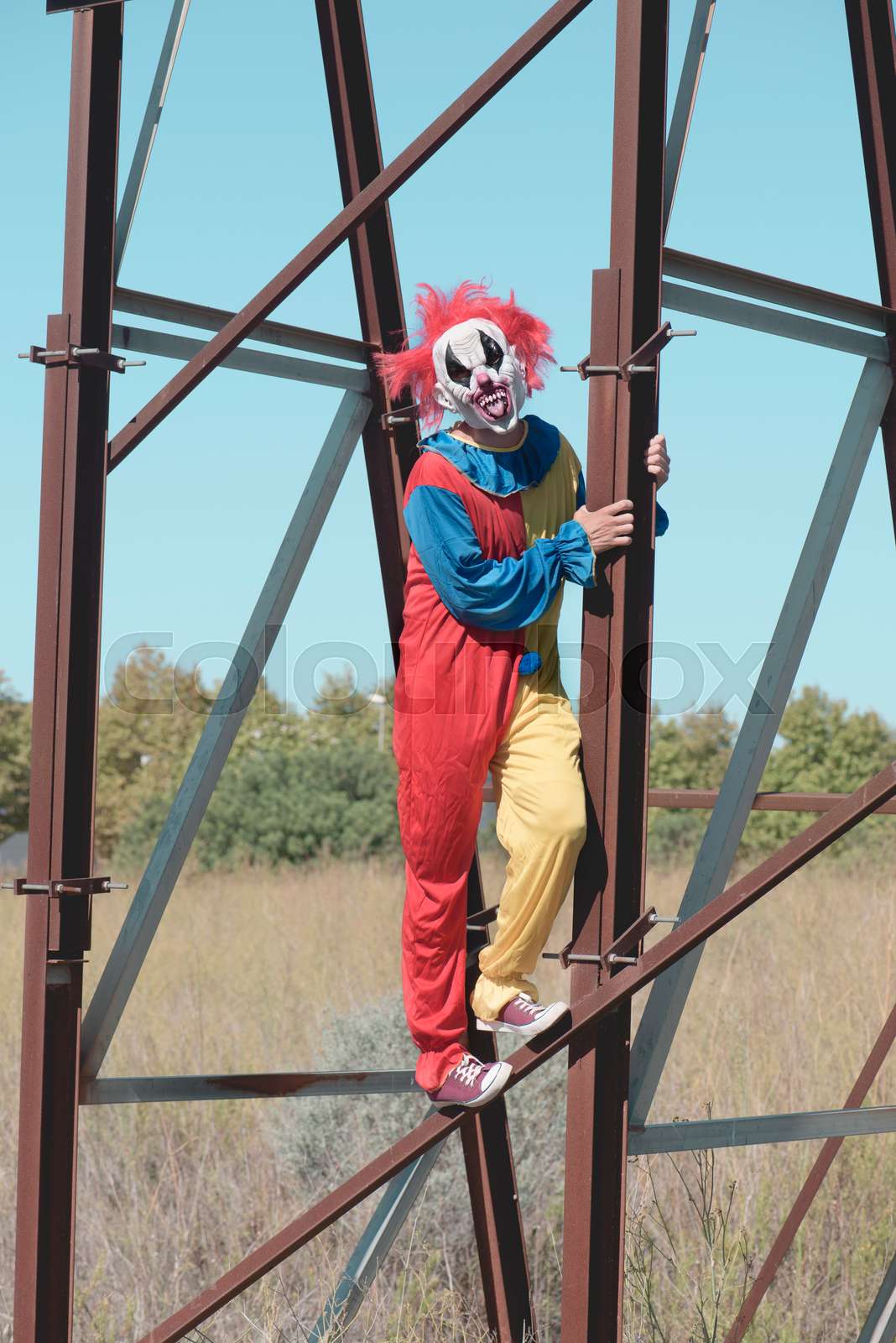 scary clown sticking out his tongue outdoors | Stock image | Colourbox