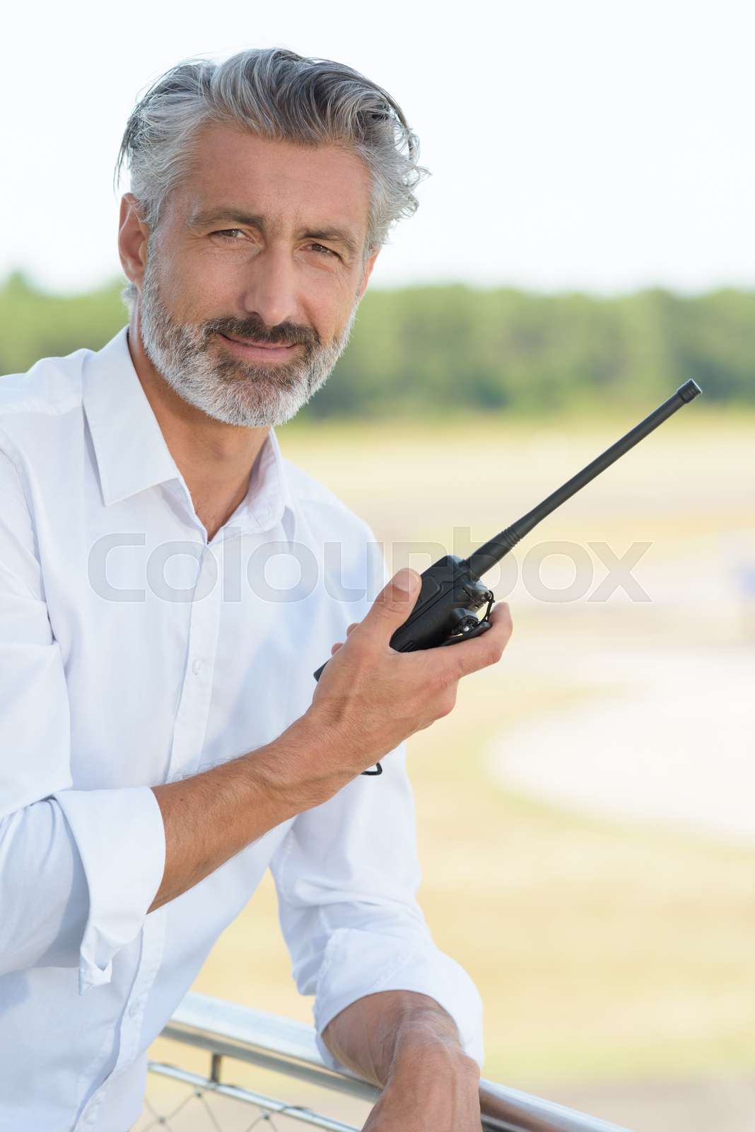 man in casual attire holding walkie talkie Stock image Colourbox