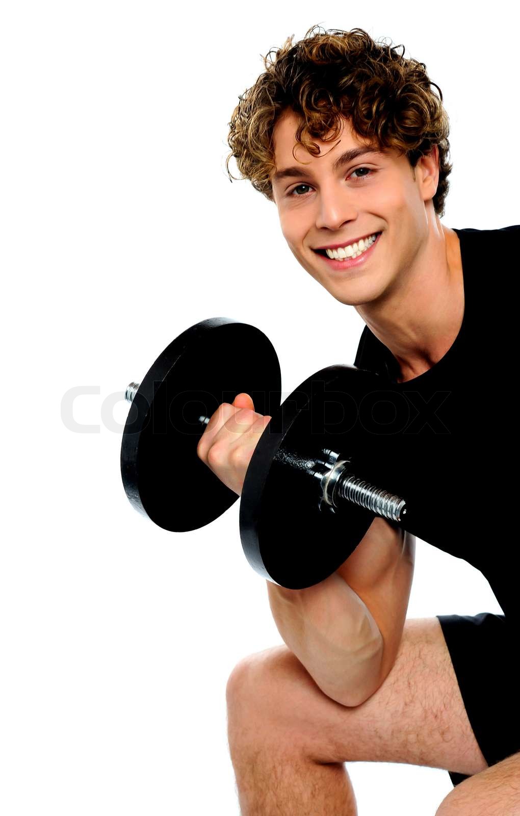 Strong young man working out with dumbbells | Stock image | Colourbox
