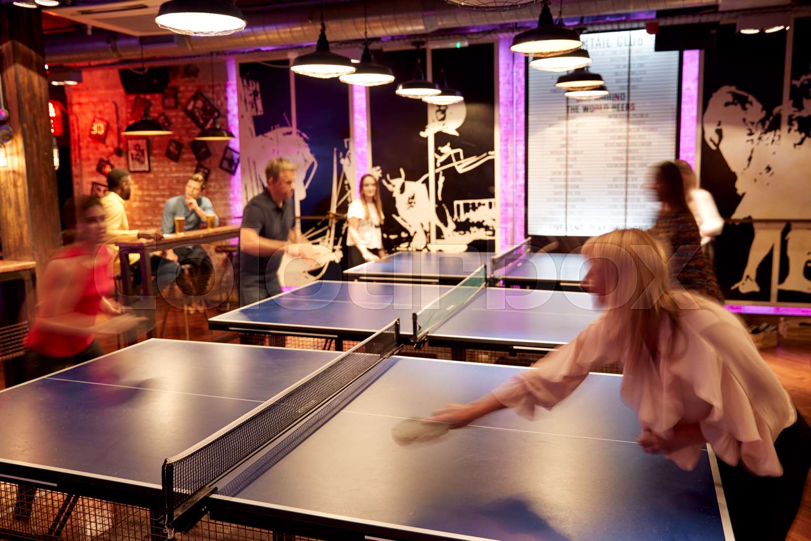 Interior Of Bar With Customers Drinking And Playing Table Tennis
