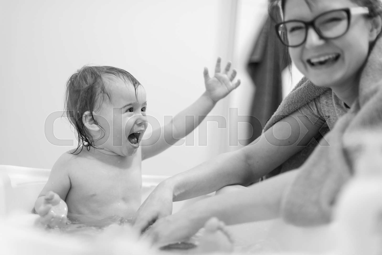 Happy 1 year old Baby in bathtub taking bath in bathroom with mother ...