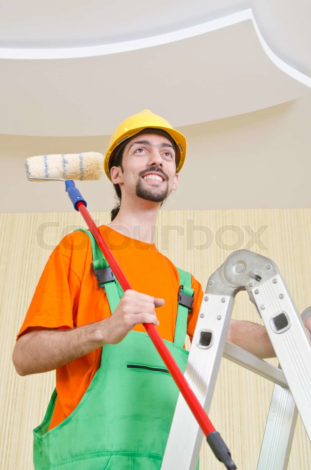 Painter worker during painting job Stock image Colourbox