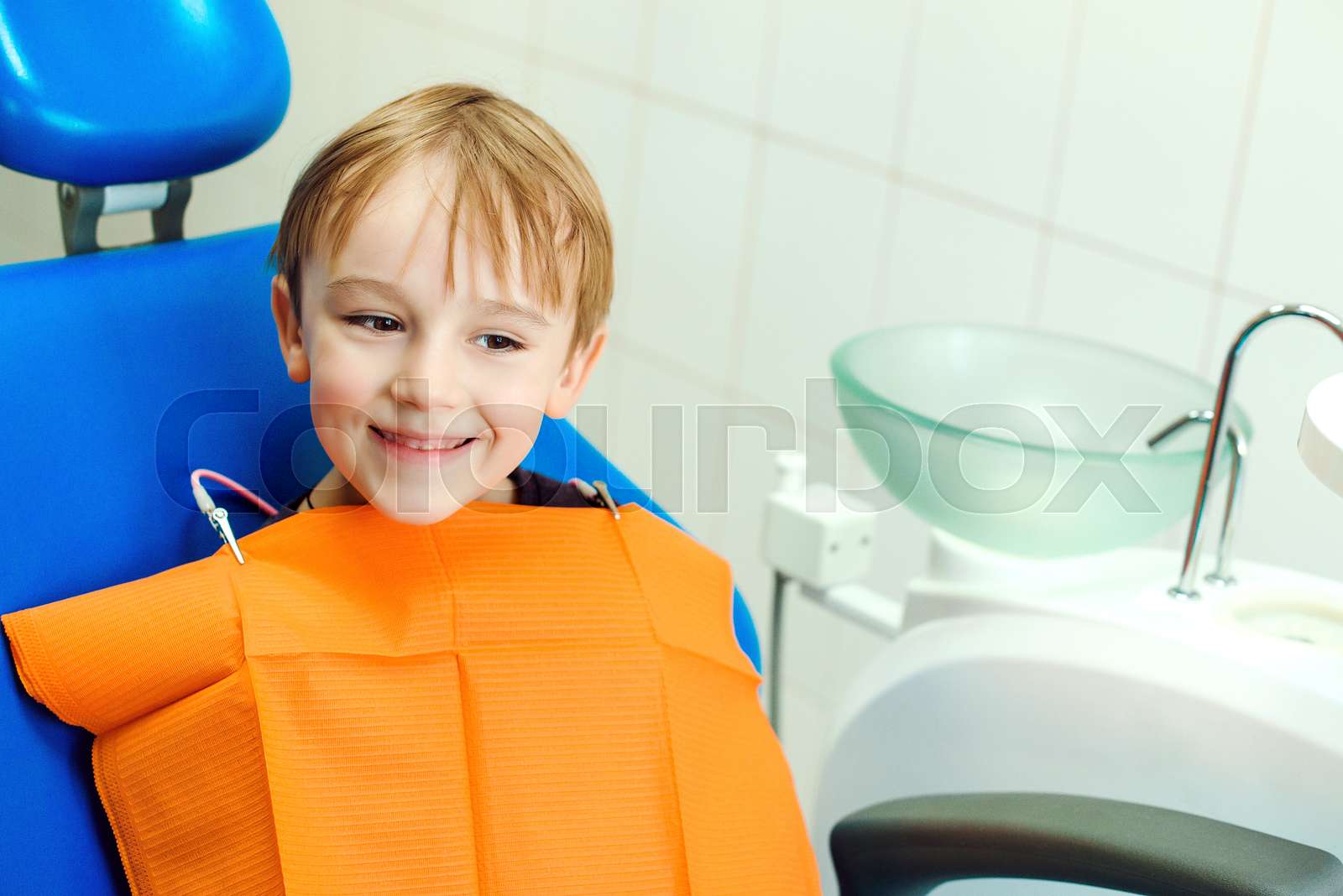 Cute Boy Sitting In Dental Chair In Room Kid Showing Teeth Happy cute-boy-sitting-in-dental-chair-in-room-kid-showing-teeth-happy