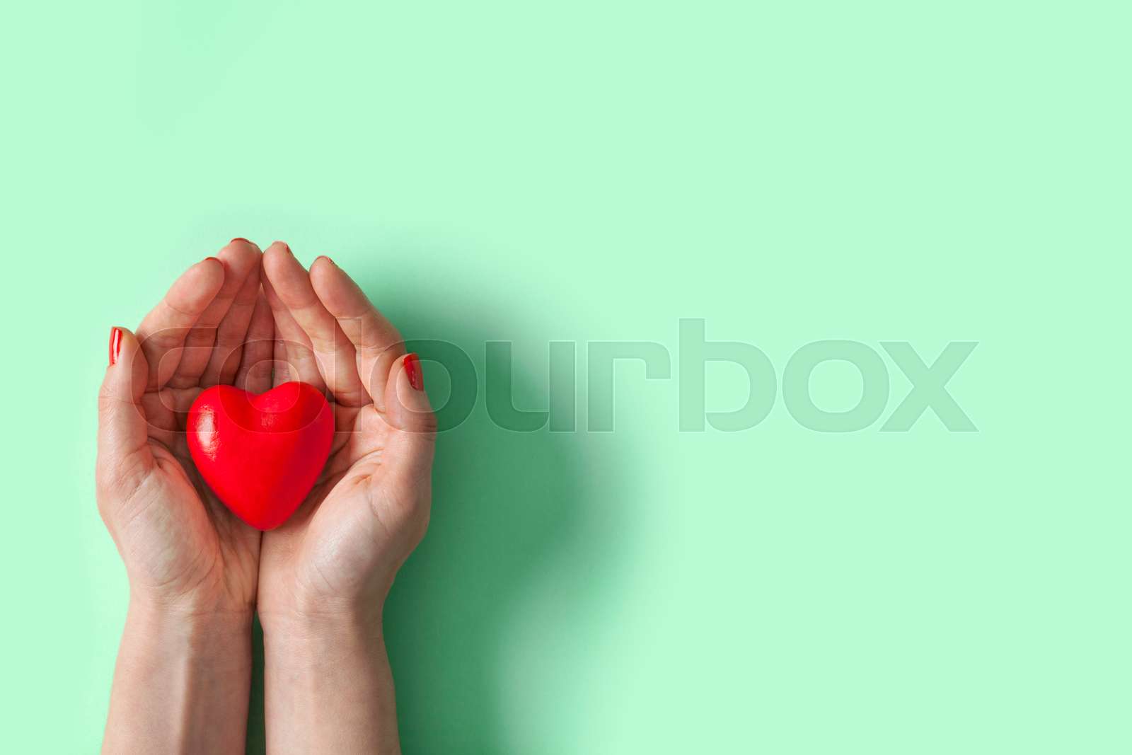 Red heart in hand Stock image Colourbox